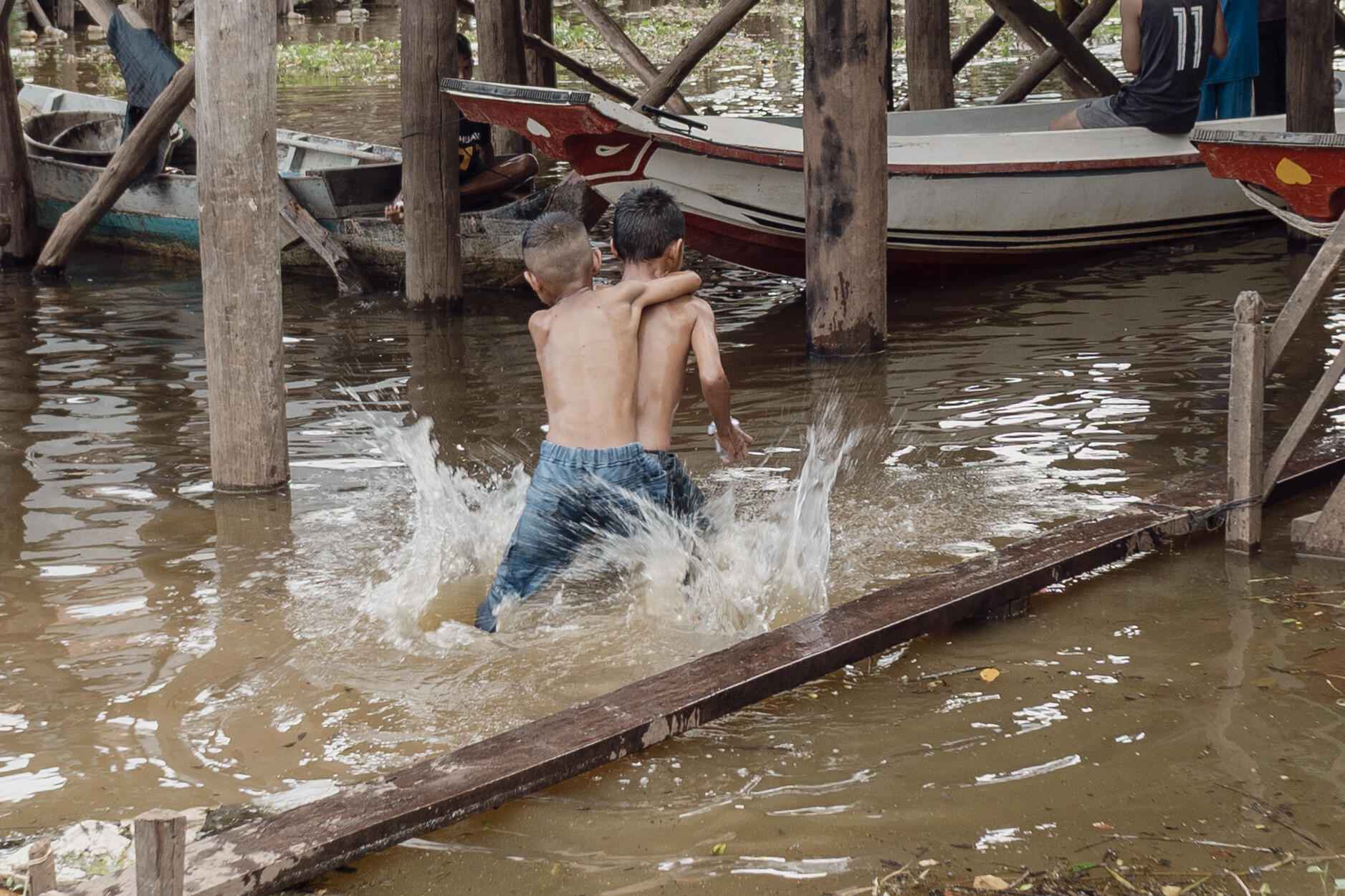 Two boys horse wrestling in a floating village near Prasat Bakong, Cambodia.